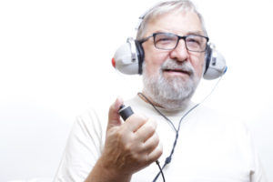 Starszy mężczyzna z słuchawkami do badania słuchu