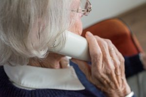 starsza kobieta z telefonem przy uchu